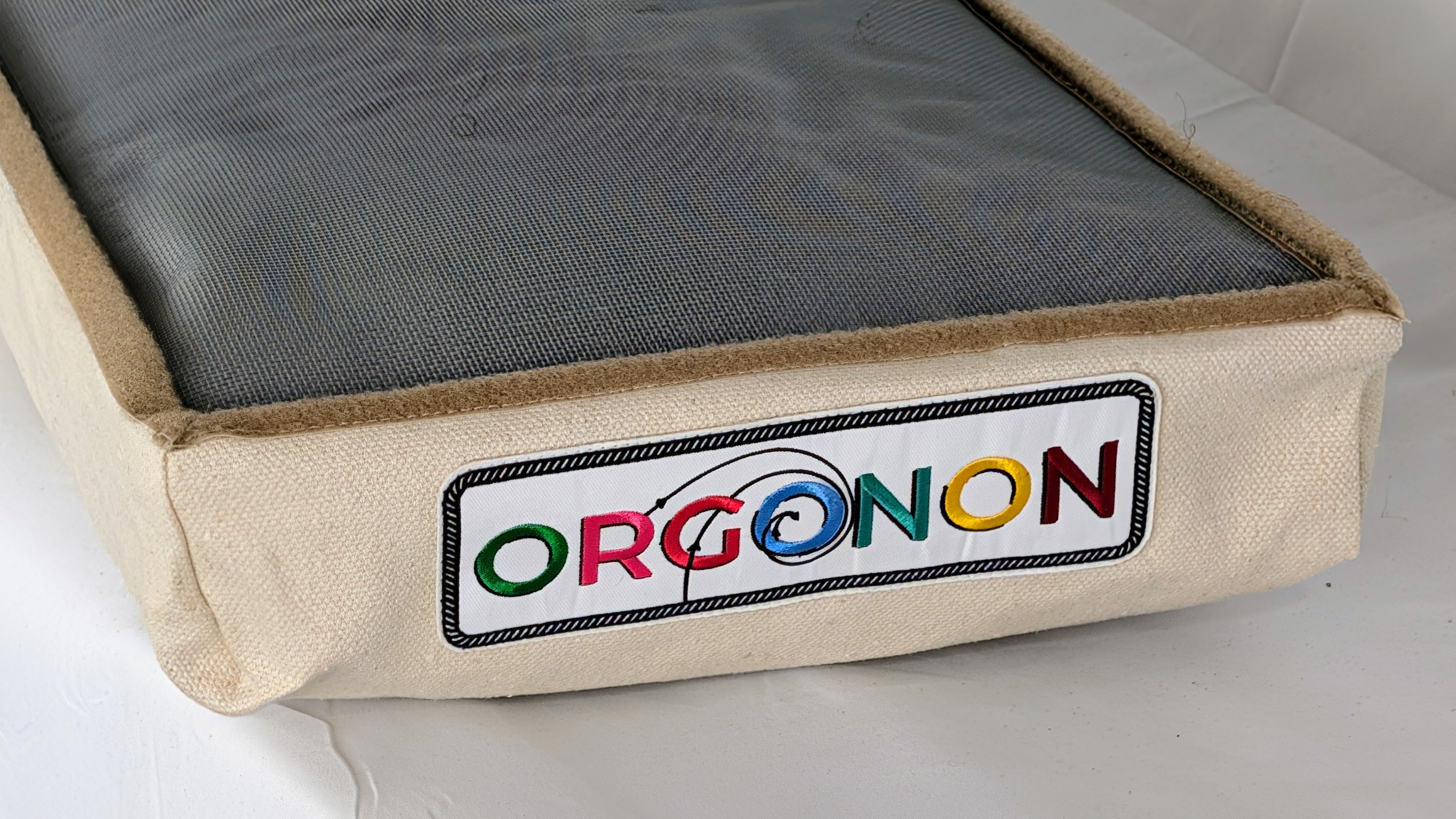 An ORGONON blanket panel with its embroidered multicolor label, galvanized screen face visible