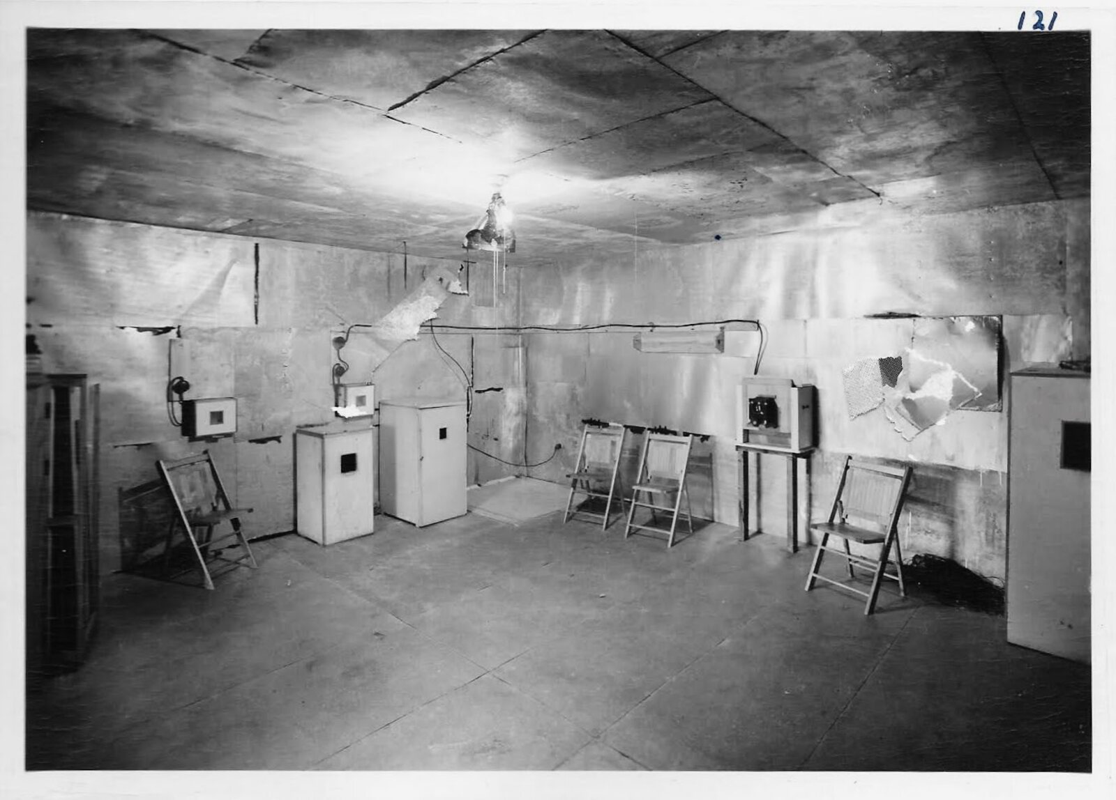 Vintage photograph of the Orgone Room interior, lined throughout with sheet metal, with small accumulators on stands and folding chairs along the walls