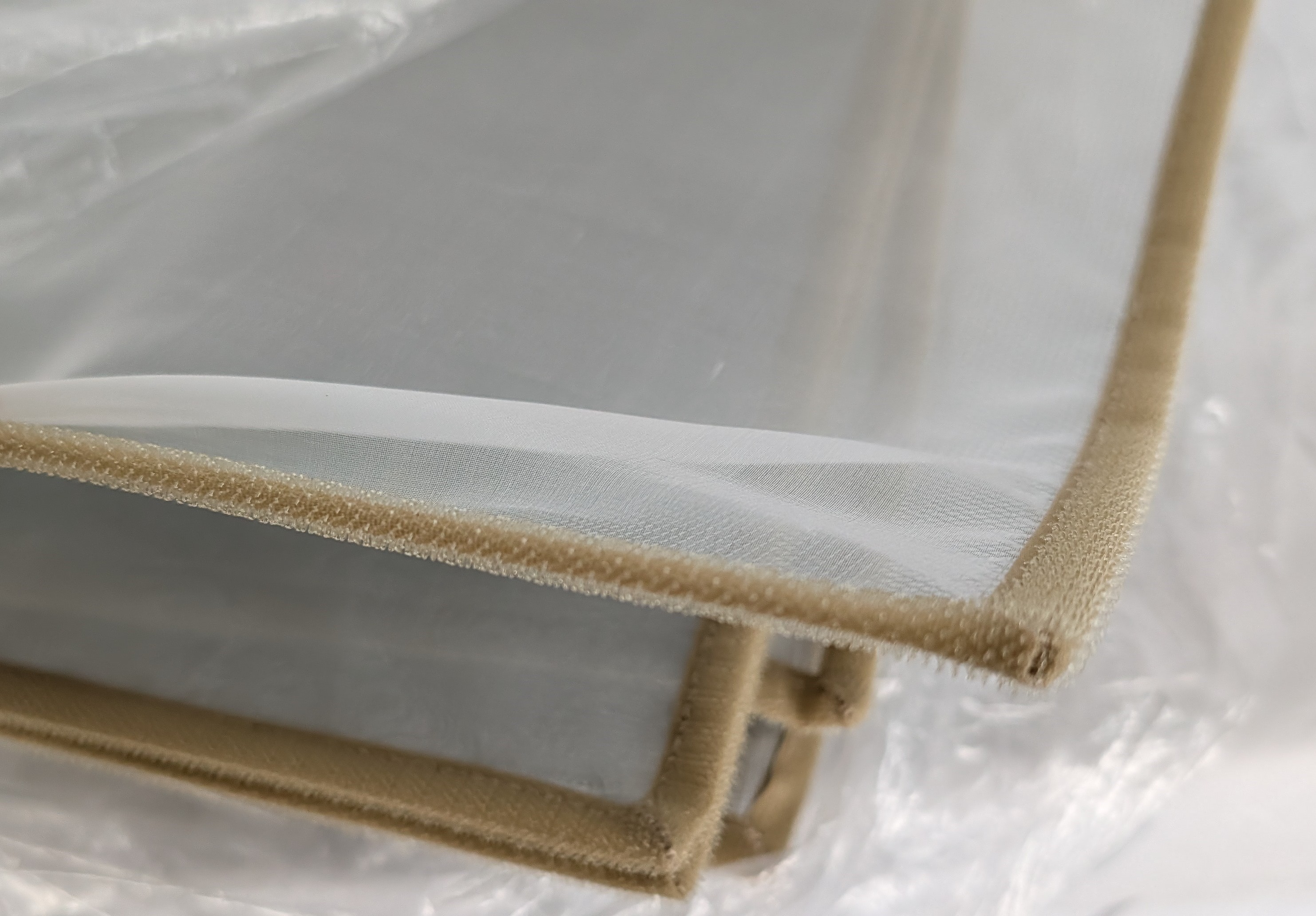 The sheer silk liner lifted to reveal the galvanized steel screen beneath