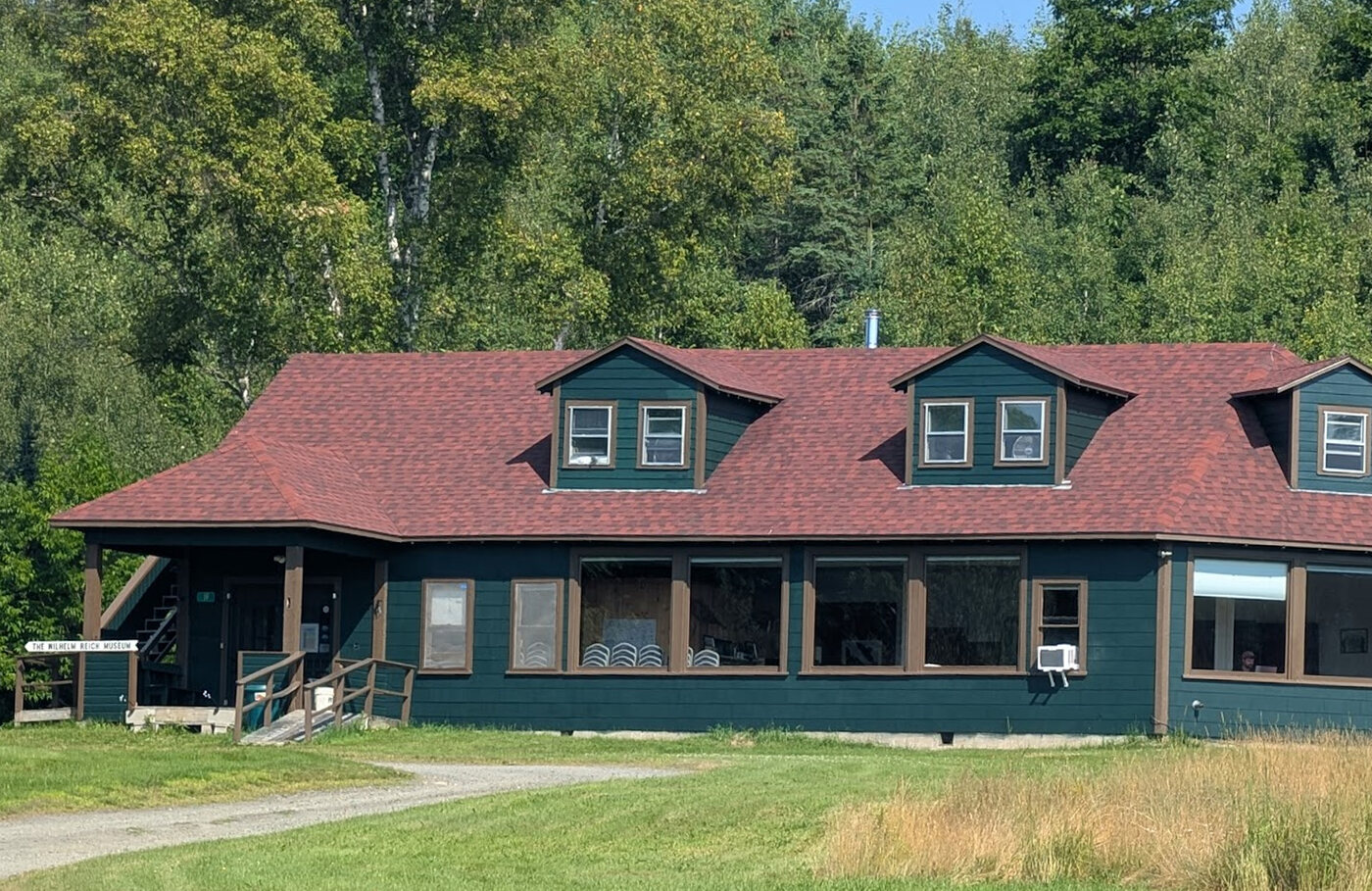 The Students' Laboratory today, green with a red shingled roof, bearing a Wilhelm Reich Museum sign