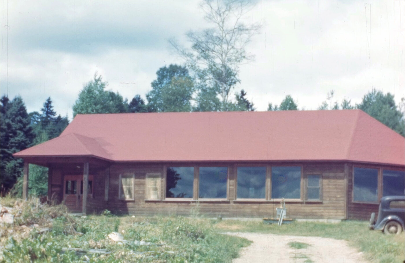 Vintage color photograph of the Students' Laboratory at Orgonon, a long wood building with a red roof and a row of large windows